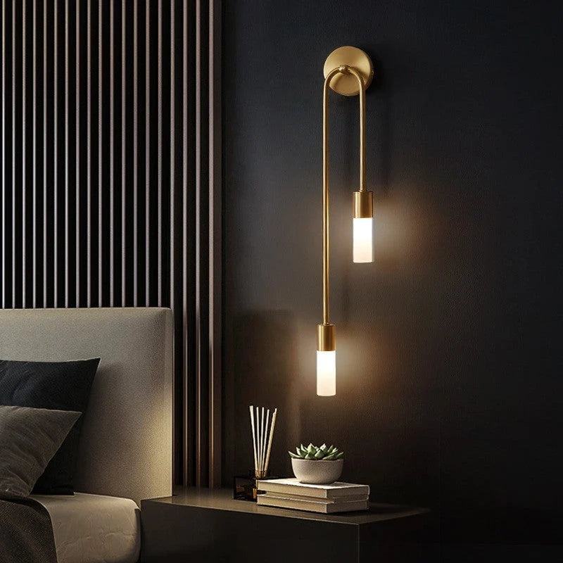 Linear Gold LED Wall Sconce - Lit Beside Bed on Dark Wall
