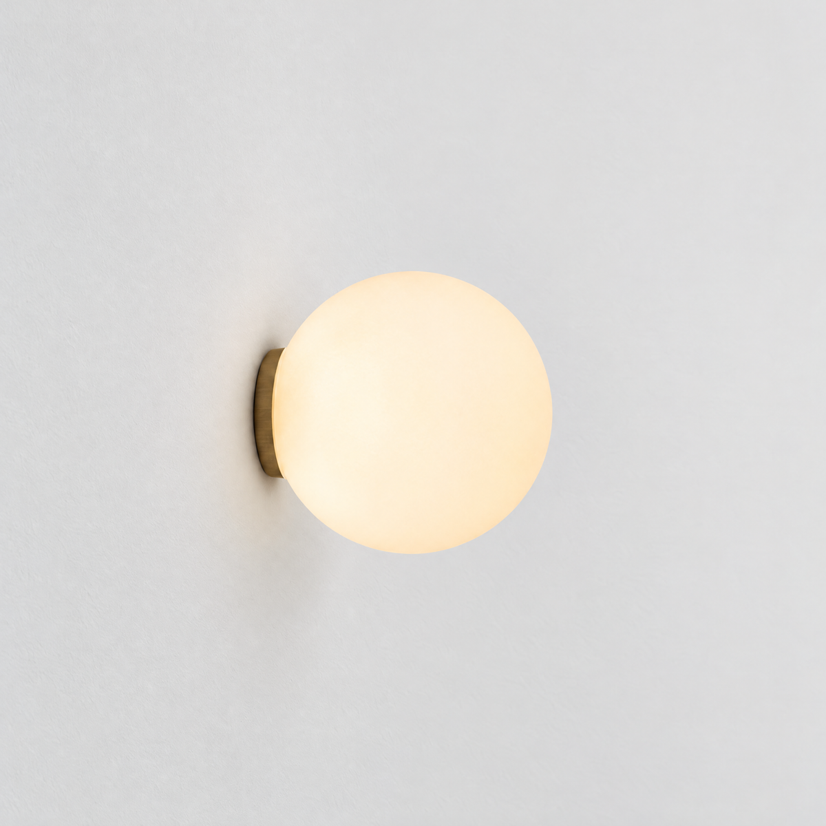 Frosted Glass Globe Wall Light - Lit on Pale Wall