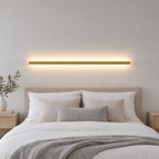Slim Linear LED Wall Light - Gold Finish Lit Above Bed