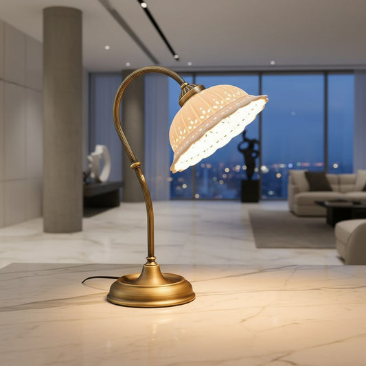 Lorvali Anita table lamp with an antique brass base and a decorative white ceramic shade on a marble surface