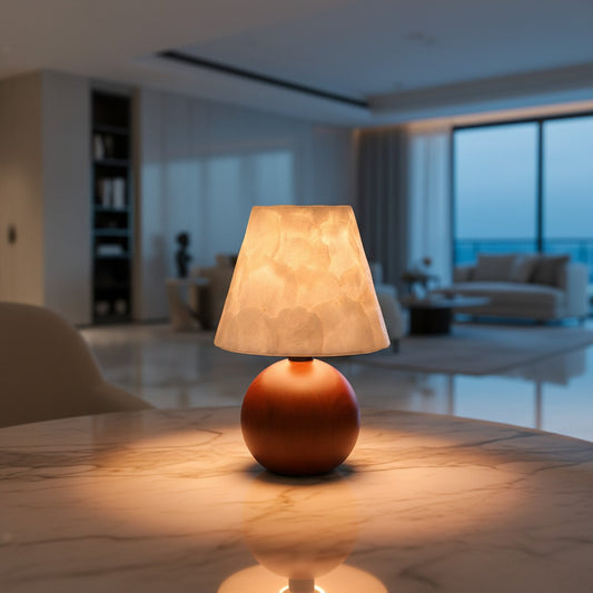 Lorvali Avery Shell Table Lamp with a spherical walnut wood base and a translucent white capiz shell shade on a table