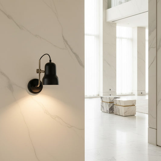 Lorvali Bauhaus style black iron adjustable wall lamp mounted on a white marble wall providing warm reading light