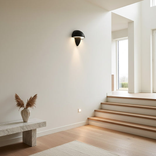 Lorvali modern black mushroom-shaped LED wall lamp mounted on a minimalist interior wall above a marble bench.
