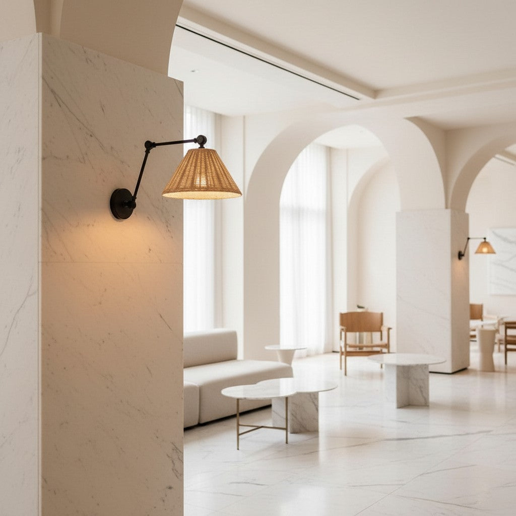 Lorvali black swing arm wall sconce with a natural rattan shade mounted on a marble pillar in a modern interior.