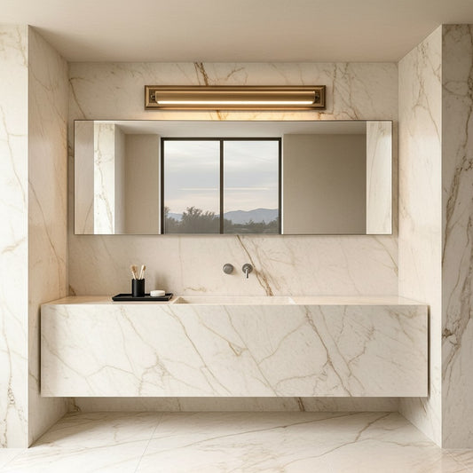 Lorvali vanity bar light in solid copper with antique bronze finish mounted above a bathroom mirror in a marble room.