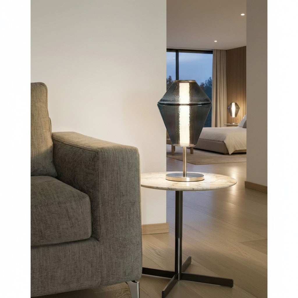 Lorvali Evette modern table lamp with a smoke gray glass shade and iron base on a marble side table in a living room.