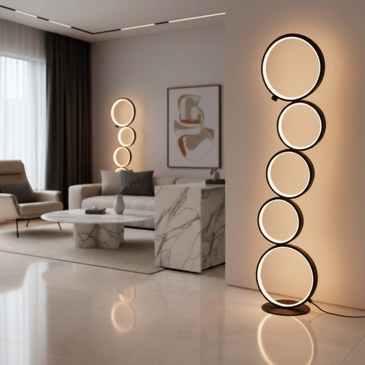 Lorvali five-ring layered LED floor lamp in matte black with a warm white glow in a modern living room setting.