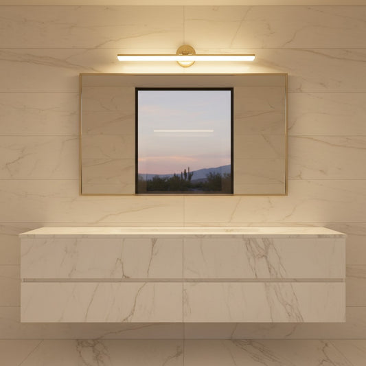 Lorvali gold LED bathroom vanity light mounted above a rectangular mirror on a marble wall in a modern bathroom.