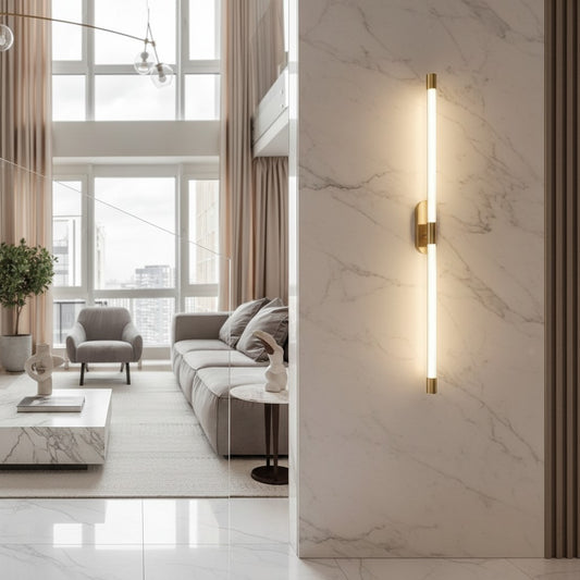 Lorvali modern linear wall sconce with a gold copper base and long white acrylic tube light in a luxury living room.