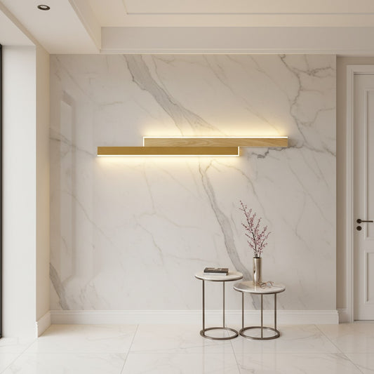 Lorvali linear LED wall light with a gold iron frame and white acrylic shade mounted on a marble wall in a hallway.