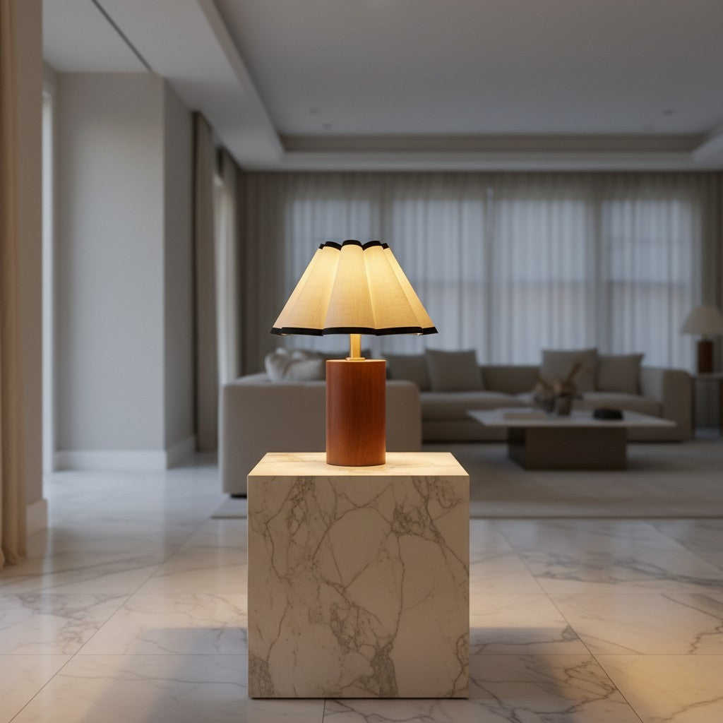 Lorvali Martin table lamp with a walnut wood base and pleated white fabric shade, set on a marble pedestal.