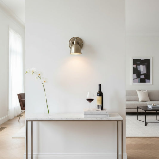 Lorvali vintage Bauhaus-style iron wall sconce in a warm metallic finish, mounted above a marble console table.