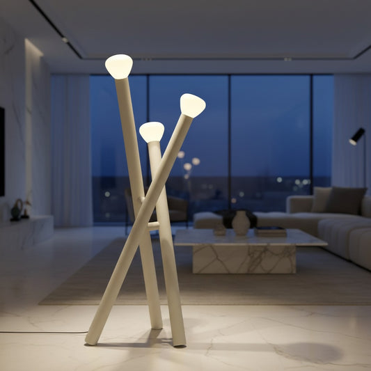 Lorvali minimalist 3-light floor lamp in matte white with crossed stick design and milky glass shades in a living room.